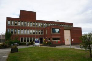 HMP Wayland. A large red brick building with many windows.