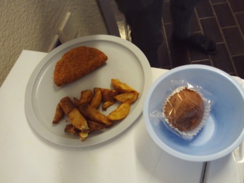 Photograph of a small evening meal at HMP Erlestoke. There is a crispy pancake and a small handful of potato wedges on one plate, and a wrapped muffin in a bowl.